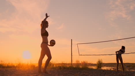 Beach-volleyball-serve---woman-serving-in-beach-volley-ball-game.-Overhand-spike-serve.-Young-people-having-fun-in-the-sun-living-healthy-active-sports-lifestyle-outdoors
